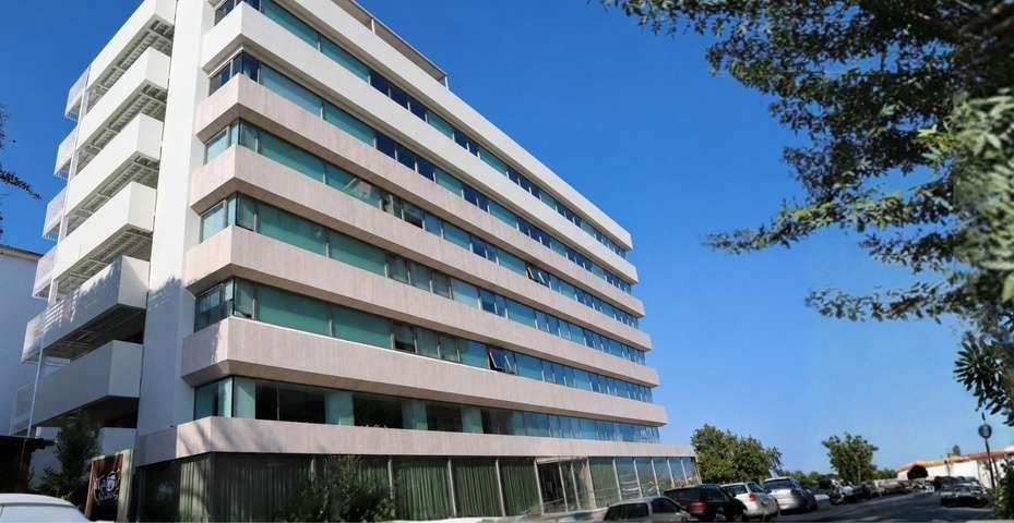 The white, glass-fronted building of Platonas Medical Center in Nicosia under a blue sky